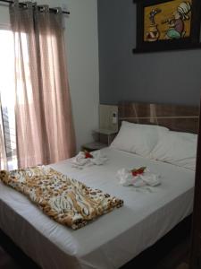 佩尼亚Pousada Suite Master Bella Mar的一间卧室配有带毛巾的床