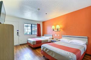 利弗莫尔利弗莫尔6号汽车旅馆的酒店客房设有两张床和橙色的墙壁。
