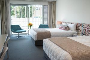 纳皮尔奈维盖特海滨公寓式酒店的酒店客房带两张床、椅子和窗户