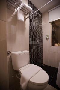雅加达快乐驿站酒店的浴室配有白色卫生间和淋浴。