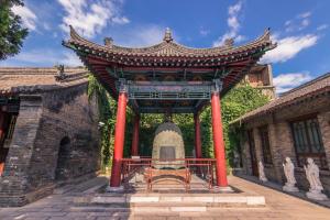 西安Jinjiang Inn Xi'An Zhonglou Metro Station Luomashi的一座建筑中一座大门,有雕像