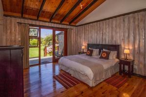 普利登堡湾皮赛因山谷小屋酒店的铺有木地板的客房内设有一间卧室和一张床。