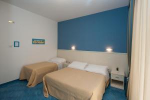 马奥莱奥西酒店的一间设有两张床和蓝色墙壁的客房
