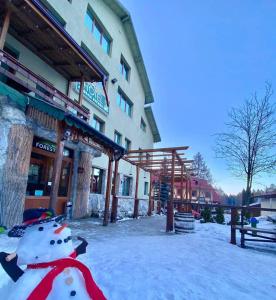 波罗维茨Hotel Forest Star on the Ski Slope的雪地里建筑物前面的雪人