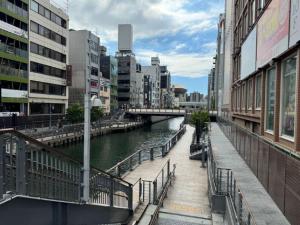 大阪Rose Lips Shinsaibashi ローズリップス心斎橋的一座建有建筑物的城市里河流上的桥梁