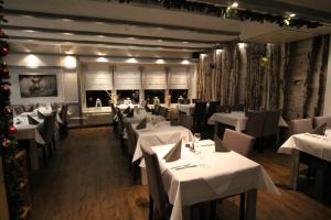 布伦瑞克艾格霍夫酒店餐厅的餐厅拥有白色的桌椅和圣诞装饰