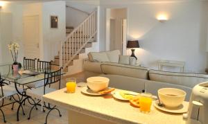 Pont-de-LarnLagrange Vacances - Royal Green的客厅配有沙发和带橙汁杯的桌子。