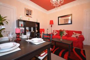斯特灵华莱士公寓的客厅配有红色的沙发和桌子