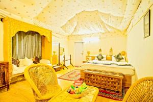 斋沙默尔JaisalmeR Sand Dunes ResorT的一间卧室配有一张床、一张沙发和椅子