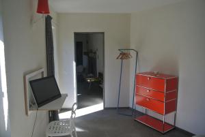 Miglieglia卡巴拉德设计公寓的一间带红色梳妆台和电视的客厅