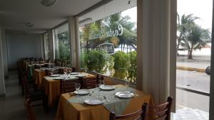 阿塔卡梅斯科斯塔帕拉伊索酒店的餐厅的一排桌子,有大窗户