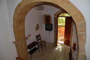 VafésPatriko Traditional Stone Houses的通往带电视的客厅的拱门