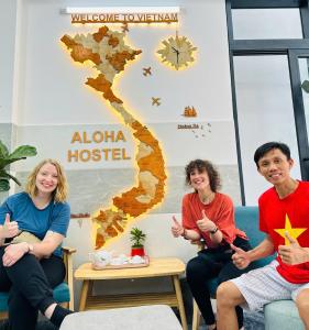 胡志明市ALOHA SAIGON HOSTEL by Local Travel Experts - Newly opened, Less-touristy location, Spacious rooms, Glass shower bathroom, Free breakfast, Quiet alley and Cultural exploration的一群人坐在一个房间里沙发上