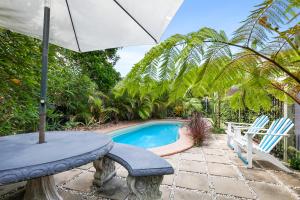 佩里吉安比奇巨浪佩里吉安海滩酒店的一个带桌子和遮阳伞的庭院和一个游泳池