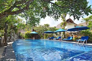 勒吉安普瑞德瓦巴哈拉塔酒店及别墅的一个带蓝色椅子和遮阳伞的游泳池