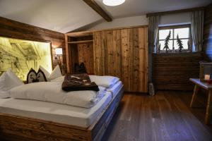 容霍尔茨安格公寓 - 浪漫 - 美容 - 康体的卧室配有一张床铺,位于带木墙的房间内