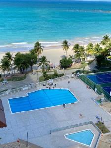 圣胡安Downtown Beachfront Isla Verde Luxury Apartment的海滩旁网球场的空中景致