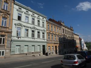 布尔诺Apartment Brno Reissigova的停在街道上建筑物前面的汽车