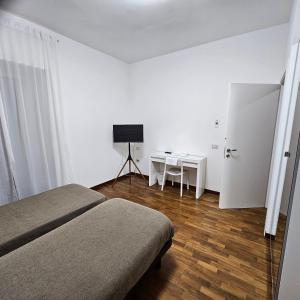 波坦察ESSENTIAL ROOM & PARKING in Centro Città con Parcheggio Privato e WIFI的一间卧室配有一张床、一张桌子和一张桌子