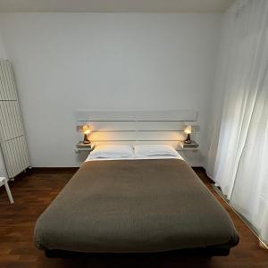 波坦察ESSENTIAL ROOM & PARKING in Centro Città con Parcheggio Privato e WIFI的一间卧室配有一张大床,两盏灯