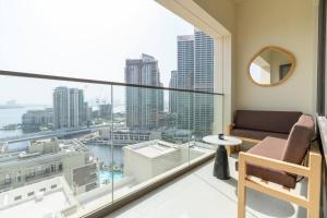 迪拜1BR Vida residences Creek Beach的阳台配有沙发,享有城市美景