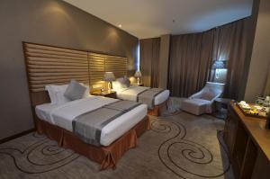 金沙萨Fleuve Congo Hotel By Blazon Hotels的酒店客房,配有两张床和椅子