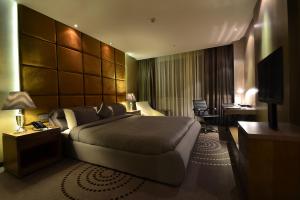 金沙萨Fleuve Congo Hotel By Blazon Hotels的酒店客房设有一张大床和一张书桌。
