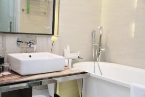 金沙萨Fleuve Congo Hotel By Blazon Hotels的浴室配有白色水槽和浴缸。