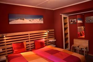 克洛斯特斯冒险旅馆 的一间卧室设有红色的墙壁和一张带红色枕头的床