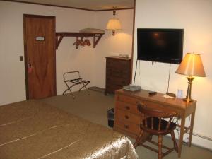 西多佛碧格瑞斯酒店的一间卧室配有一张床和一个带电视的梳妆台