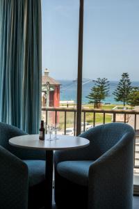 纽卡斯尔Alloggio Newcastle Beach的一张桌子和椅子,享有海景