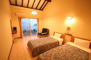 西表岛伊尔梅尔纳里撒基酒店的酒店客房设有两张床和一个阳台。