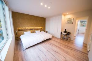 函馆拉卡谢特公寓的卧室设有一张白色大床和木地板
