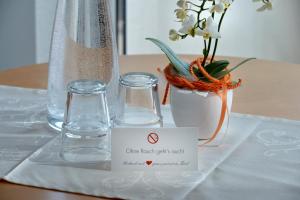 埃布斯霍讷膳食公寓的一张桌子,上面有两杯眼镜,花瓶