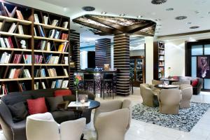 日利纳Boutique Hotel Dubná Skala的图书馆设有书架和桌椅