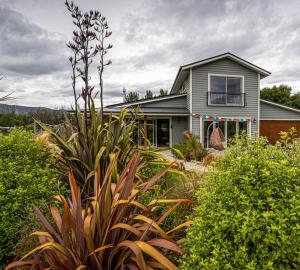 LuggateThe Artist's House Wanaka的前面有大量植物的房子