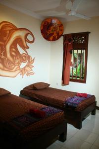 日惹马拉姆1001酒店的客房设有两张床和一扇墙上有龙的窗户。