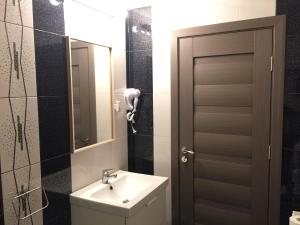 布加勒斯特麦克酒店的一间带水槽、镜子和门的浴室