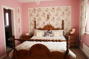 卡尔达夫Ceecliff House的卧室配有一张带粉红色墙壁的大床