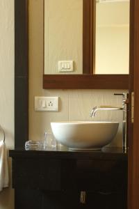 孟买阿米戈酒店的浴室的柜台设有水槽和镜子