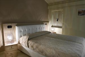 代森扎诺-德尔加达Alessi Hotel Trattoria的一间卧室配有一张带白色床头板的大床
