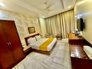 新德里GTB Florence Inn, 2min walk from Karol Bagh Metro的酒店客房,配有床和电视