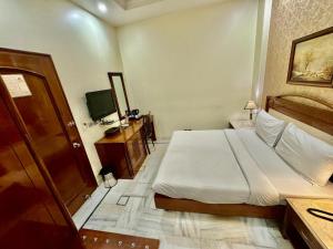 新德里GTB Florence Inn, 2min walk from Karol Bagh Metro的一间卧室配有一张大床和电视