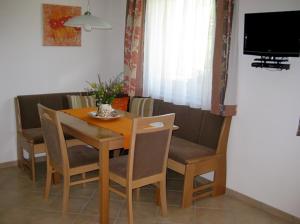阿尔卑巴赫Apartment Galtenberg的餐桌、椅子和电视
