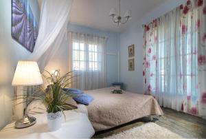 新马尔马拉斯希腊之家酒店的一间卧室配有一张床和一张带台灯的桌子