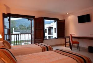 圣洛伦索Posada de los Poetas Hotel Boutique的酒店客房设有两张床和一个阳台。