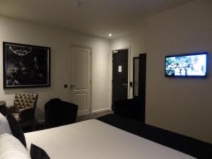 阿姆斯特丹萨拉精品酒店的酒店客房设有一张床和墙上的电视