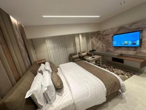 利雅德استديو فاخر اثاث عصرى - Luxury studio with modern furniture的一间卧室配有一张大床和一台平面电视