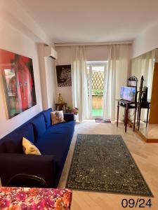 蒙特卡罗Very Central suite apartment with 1bedroom next to the underground train station Monaco and 6min from casino place的客厅设有蓝色的沙发和窗户。