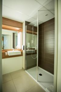 第戎第戎克莱蒙梭钟楼会议酒店的一间带玻璃淋浴和水槽的浴室